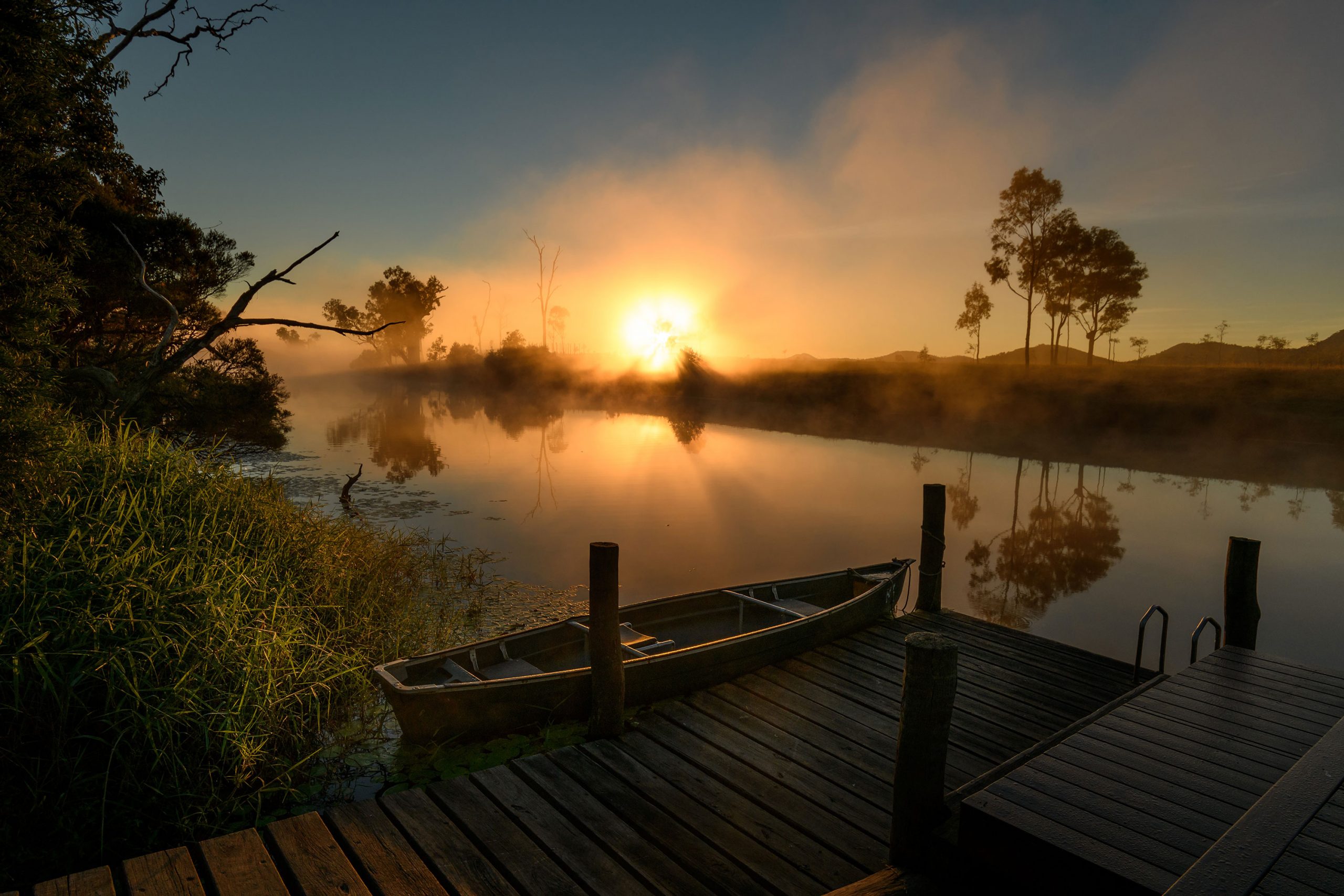 sunrise over lake with boat