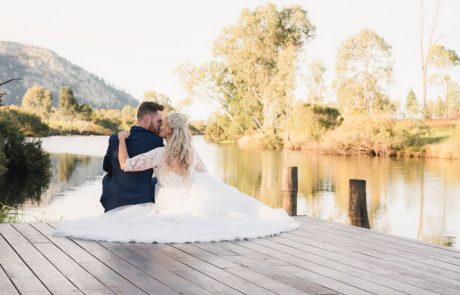 bride and groom sitting on dock