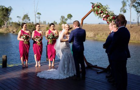 bride laughing holding grooms hands at ceremony