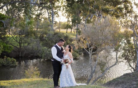 Bride and Groom embracing next to creek